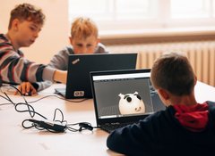 drei Jungen arbeiten an Laptops