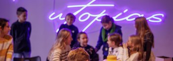 Kinder stehen um einen Tisch und bauen mit Lego
