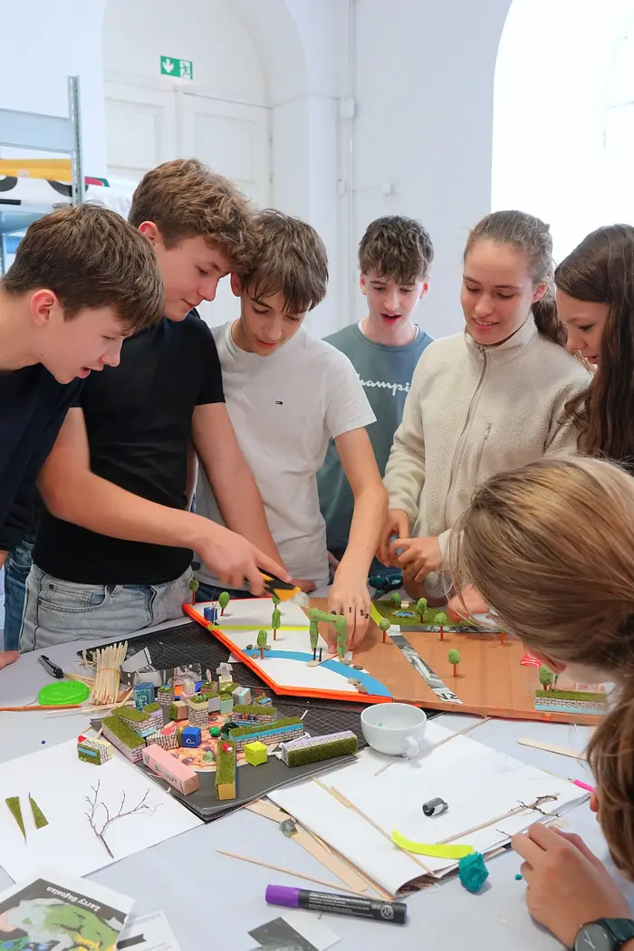 eine Gruppe Jugendlicher steht an einem Tisch