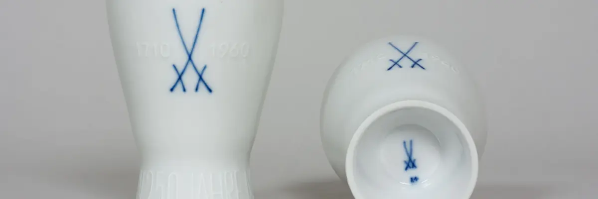 zwei Porzellanbecher, einer davon liegend