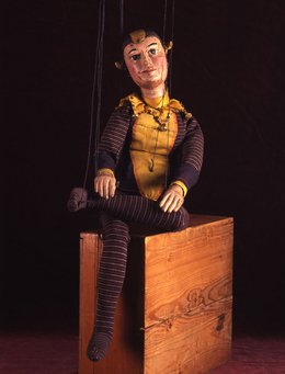 Marionette, die auf einer Kiste sitzt
