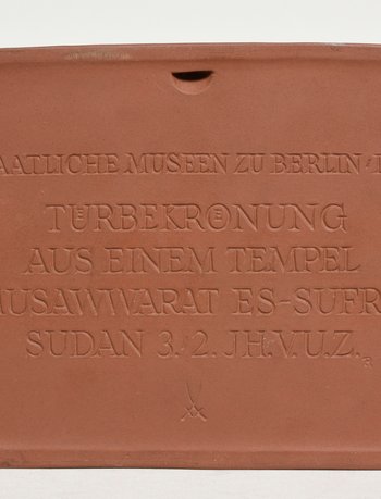 terracottafarbener Gegenstand mit einer Inschrift