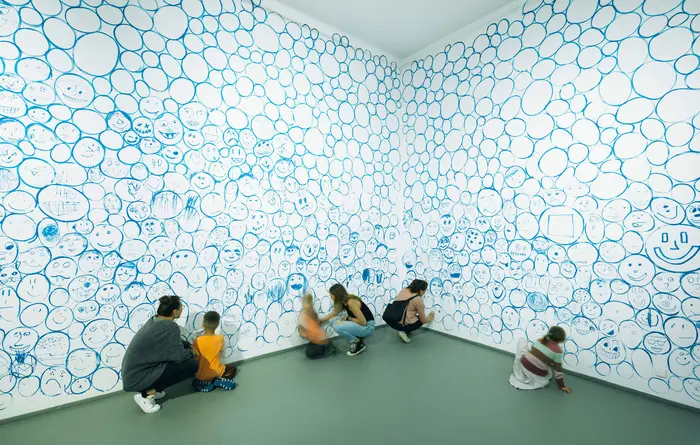 Wand mit blauen Gesichtern