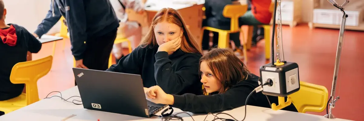 zwei Mädchen arbeiten an einem Laptop
