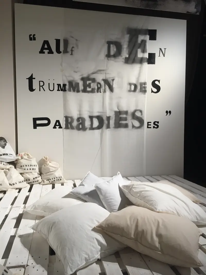 Eine Installation mit Kissen, Brettern und einer beschrifteten Leinwand.