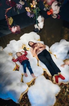 Mutter und Kind liegen auf zwei flauschigen Kissen